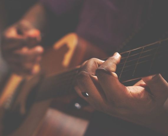 Zbliżenie na dłonie grające na gitarze